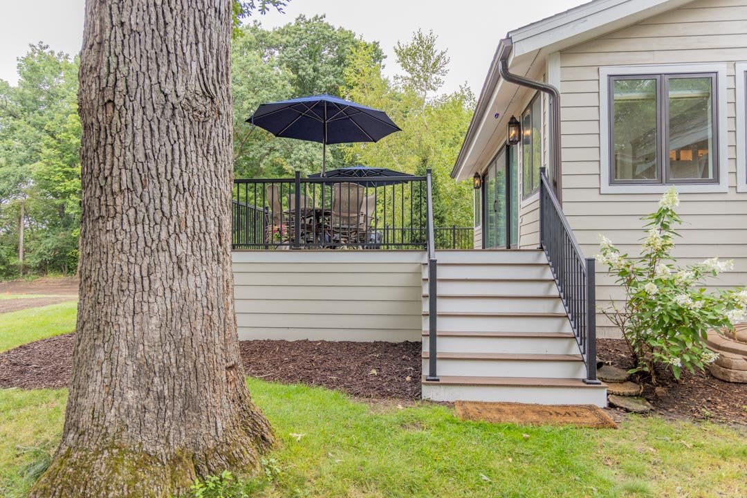Deck stairs with composite treads and metal handrail